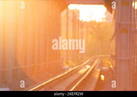 Orange glow of the sun on a blurred background of railway tracks in the tunnel. Rails of railway tracks Stock Photo