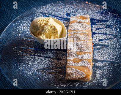 strudel and vanilla ice cream on the plate and powdered sugar.Apple strudel - Apfelstrudel  - Strudel di Mele Stock Photo