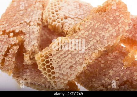 Pieces of honeycomb, filled with liquid honey, on a white background Stock Photo