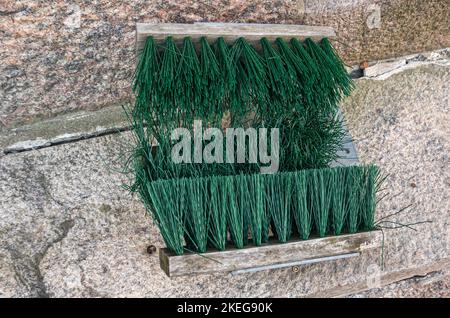 Helsinki, Finland - July 20, 2022: Pohjoissatama Harbor. Closeup, green broom contraptiion to remove snow from shoes at entrance to condominium buildi Stock Photo