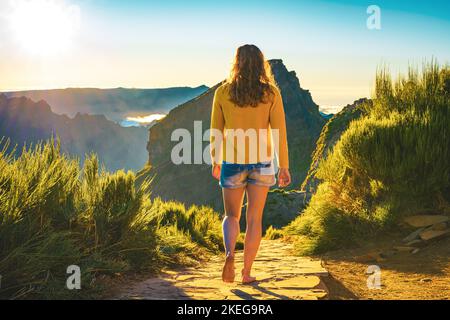 Description: Sporty woman walking barefoot in the evening sun on Pico do Ariero on a super beautiful hiking trail. Verade do Pico Ruivo, Madeira Islan Stock Photo