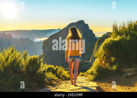 Description: Sporty woman walking barefoot in the evening sun on Pico do Ariero on a super beautiful hiking trail. Verade do Pico Ruivo, Madeira Islan Stock Photo