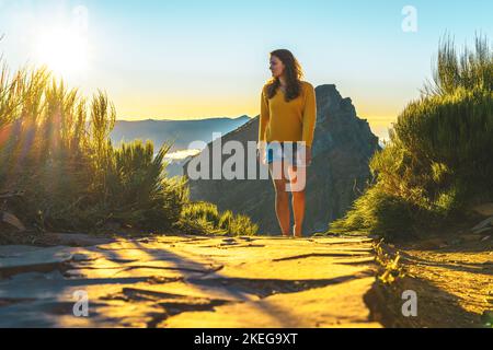 Description: Sporty woman walking barefoot in the evening sun on Pico do Ariero on a super beautiful hiking trail. Verade do Pico Ruivo, Madeira Islan Stock Photo