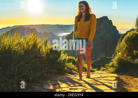 Description: Sporty woman walking barefoot in the evening sun on Pico do Ariero on a super beautiful hiking trail. Verade do Pico Ruivo, Madeira Islan Stock Photo