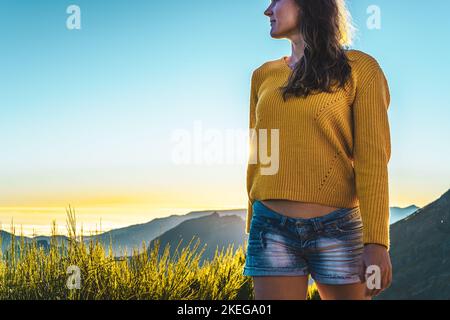 Description: Sporty woman walking barefoot in the evening sun on Pico do Ariero on a super beautiful hiking trail. Verade do Pico Ruivo, Madeira Islan Stock Photo