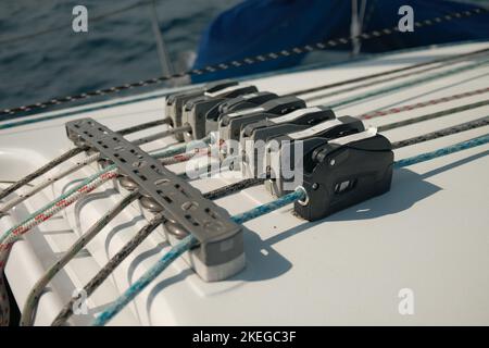 A closeup of a sailboat rope stopper on a white boat on the ocean Stock Photo