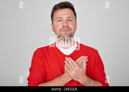 Happy man smiling while holding hands on his chest  Stock Photo
