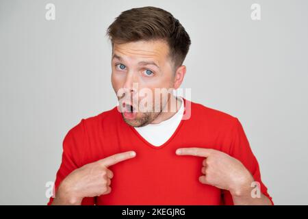 Indignant young man looks puzzled points at himself feels displeased.  Stock Photo