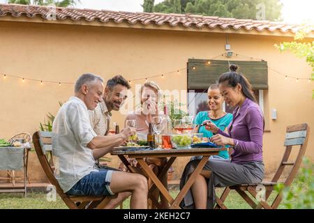 Mature friends enjoying eating happy smiling and laughing during weekend. Stock Photo