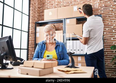 Mother and son business workers using laptop and smartphone at office ...