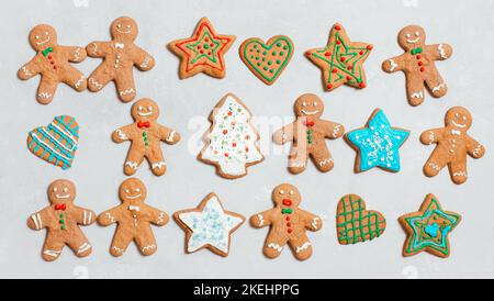 Christmas cookies on gray background. Homemade ginger cookies with colorful glaze. Gingerbread man, star and Christmas tree. Top view, flat lay. Stock Photo