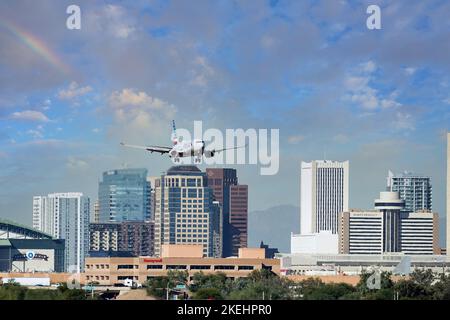 Phoenix, Arizona, USA - November 4, 2022: American Airlines jet on approach to Phoenix Airport in Arizona with skyline of Phoenix in background. Stock Photo