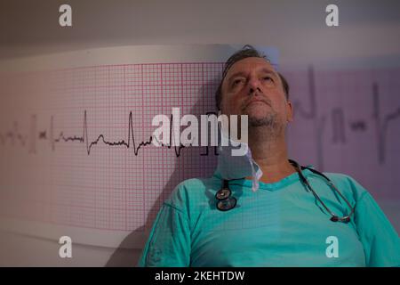 a doctor staring into the sky overlaid with an electrocardiogram concept of cardiovascular disorder or cardiovascular checks Stock Photo