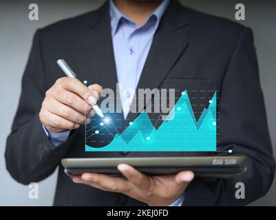 businesspeople using a tablet to view company financial reports, and graphics showing financial and numerical growth data. The concept of financial ma Stock Photo