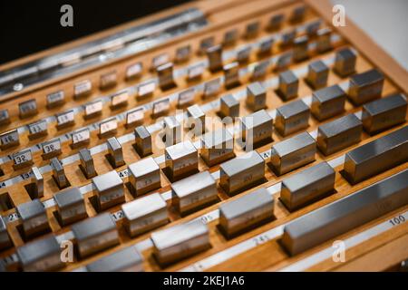 Set of metal weight reference standards on wooden tray Stock Photo