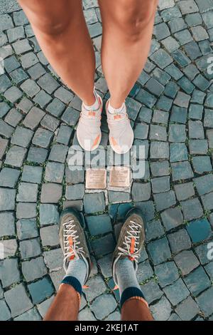 26 July 2022, Munster, Germany: Cobblestones Stolpersteine on a pedestrian path as memorial for died and deported jews victims during holocaust Stock Photo