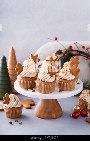 Gingerbread cupcakes with cream cheese frosting topped with gingerbread cookies Stock Photo