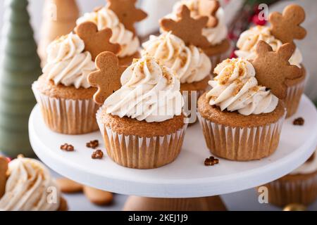 Gingerbread cupcakes with cream cheese frosting topped with gingerbread cookies Stock Photo