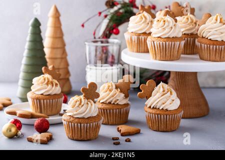 Gingerbread cupcakes with cream cheese frosting topped with gingerbread cookies Stock Photo