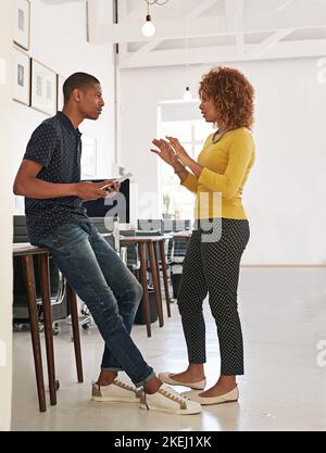 These are our options...two colleagues having a discussion in a modern office. Stock Photo