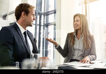 Talking successes. a two executives working together in an office. Stock Photo