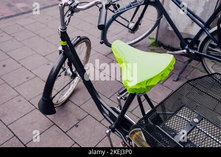 rain cover on the seat or saddle of an urban bicycle Stock Photo