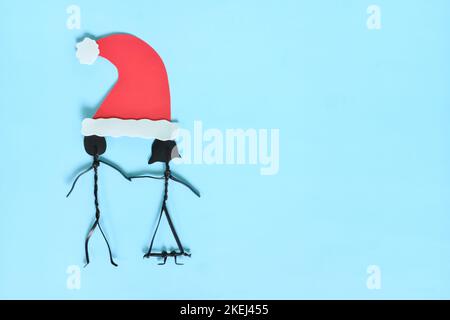 Christmas season sharing and togetherness concept. Man and woman couple together in one santa hat. Stock Photo