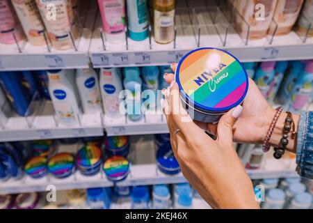 26 July 2022, Munster, Germany: Woman customer choosing Nivea cream among Various cosmetic products for sale in beauty store Stock Photo