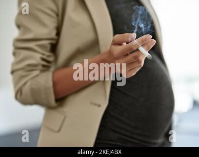 Your babys health is paramount. a woman smoking a cigarette while preganant. Stock Photo