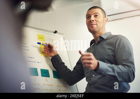 Hes got a plan of action. a man giving a presentation to colleagues in an office. Stock Photo