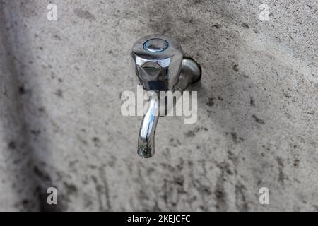 Faucet mounted on a stone wall. Top view of the faucet. Stock Photo