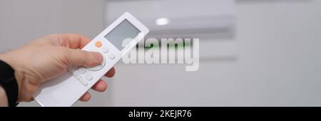 Person manual air conditioner with remote control closeup Stock Photo
