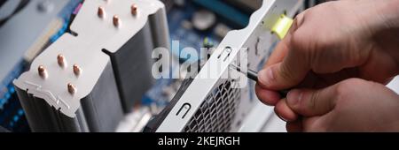 Technician repairing computer power supply closeup, Computer disassembly Stock Photo