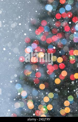 Part of Christmas tree in multicoloured lights and lots of snowflakes - soft focus Stock Photo