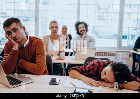 Tired woman napping on the table during a lecture in the classroom Stock Photo