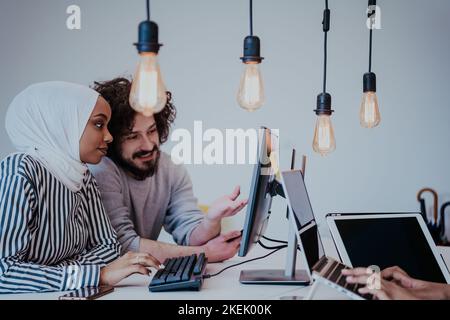 An African American woman Muslim is discussing a project with a friend in a modern office Stock Photo