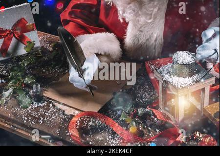 Santa claus writes a letter good wishes for Christmas gifts Stock Photo