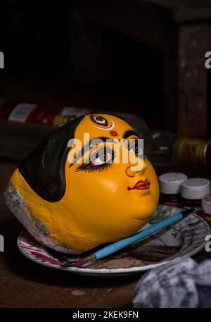 Idol face of Goddess Durga kept on plate after painting. Selective Focus on idol with other blurred. Stock Photo