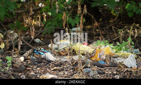 on ground, on side of road, lots of garbage is lying. scattered trash, rubbish, old things, car tires, broken glass, plastic. garbage dump. ecology, pollution of the environment. High quality photo Stock Photo