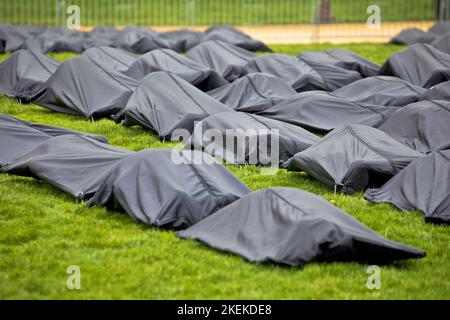 Body bags on green meadow, crime scene concept Stock Photo