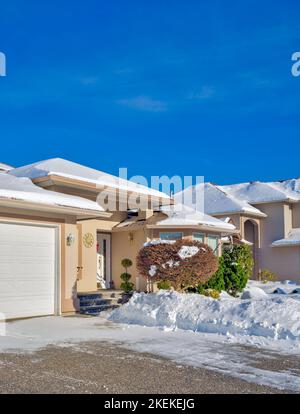 Entrance of luxury house with driveway and front yard in snow Stock Photo