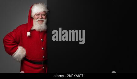 Santa Claus holding black banner with copy space for text Stock Photo