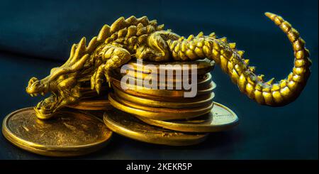 Golden dragon statue sleeping on top of gold coins Stock Photo