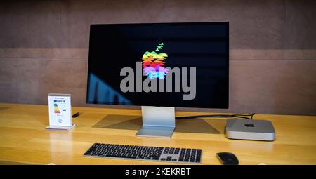 Paris, France - Oct 28, 2022: new Apple Computers MacMini computer workstation with M2 M3 CPU connected to the Studio Display 5k Retina monitor showing Apple colorful logotype Stock Photo