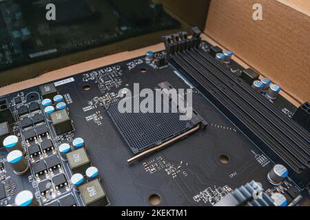 The black computer motherboard lies in a box after repair Stock Photo