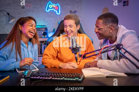 Young happy multiracial people performing at radio program making podcast recording for online show Stock Photo