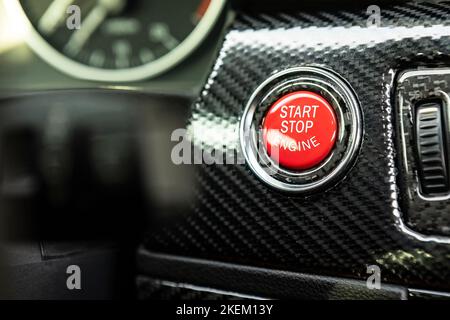 Red engine start button detail. Car dashboard with focus on red engine start stop button, car interior details. button engine start and engine stop, C Stock Photo
