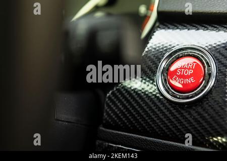 Red engine start button detail. Car dashboard with focus on red engine start stop button, car interior details. button engine start and engine stop, C Stock Photo