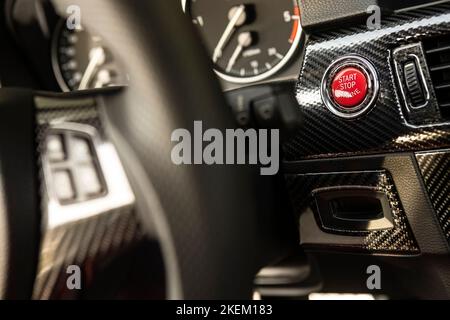 Red engine start button detail. Car dashboard with focus on red engine start stop button, car interior details. button engine start and engine stop, C Stock Photo