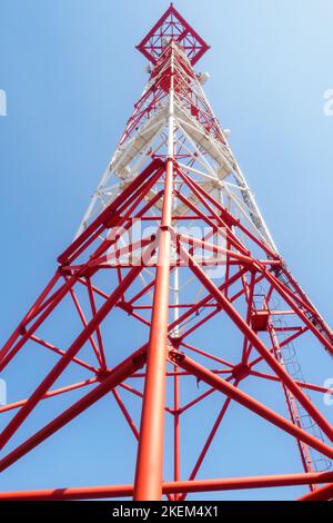 View of communication tower from bottom up against blue sky.. Stock Photo